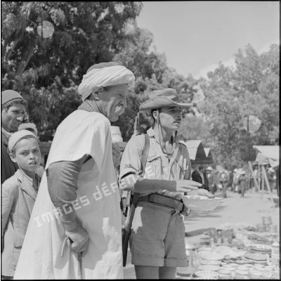 Le soldat Prosper Kaim de la 4e compagnie du 1er bataillon du 9e régiment d'infanterie coloniale (RIC) achètant un plat au marché de Rébeval.