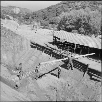 Des ouvriers dans un "entonnoir" chargé de minerai à la mine d'El Alia.