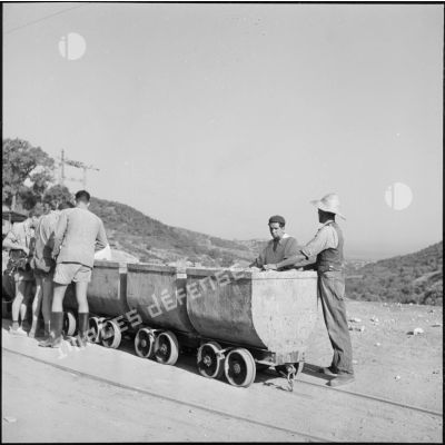 Des ouvriers de la carrière de Fil Fila chargent un chariot de pierres.