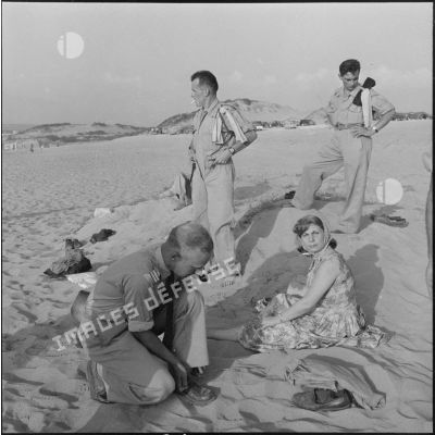 Une étudiante d'Alger et des rappelés du 3e bataillon du 2e régiment d'infanterie (RI) sur la plage de Sidi Ferruch.
