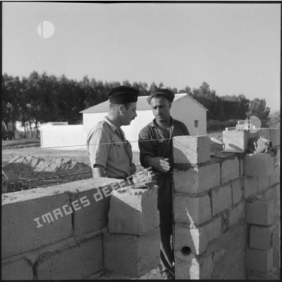 Le sergent-chef Cayron du 52e BG donnant des conseils à un ouvrier.