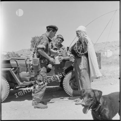 Un habitant de la région de Bordj Bou Arreridj offrant de l'eau à deux soldats du 3e régiment étranger de parachutistes (REP).