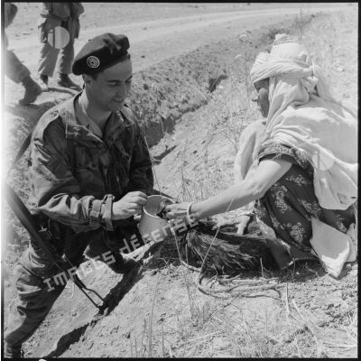 Distribution d'eau à un soldat du 3e régiment étranger de parachutistes (REP).