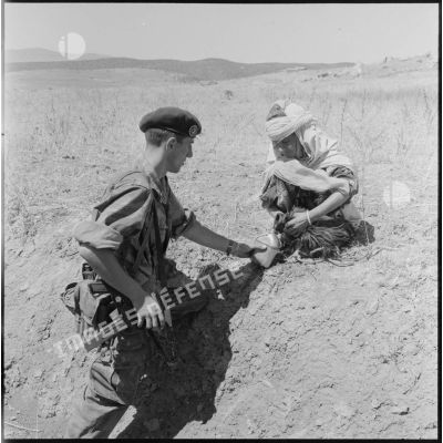 Une habitante de la région de Bordj Bou Arreridj offrant de l'eau à un élément du 3e régiment étranger de parachutistes (REP).