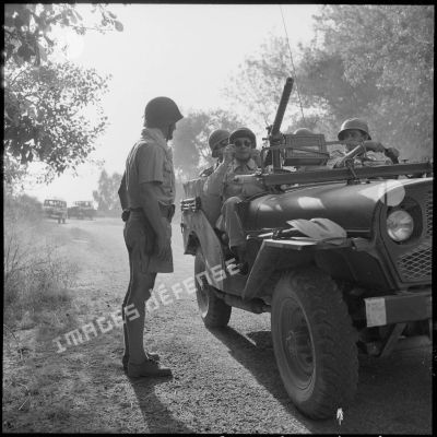 Des soldats à bord d'une jeep Delahaye sur les lieux de la fusillade.