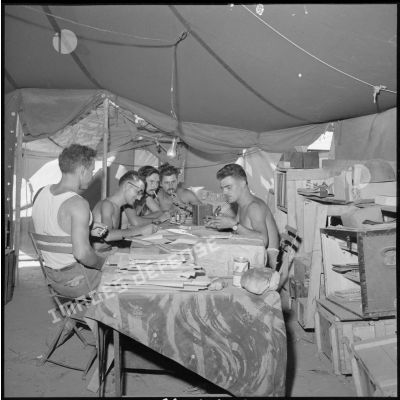 Des soldats de la 1re compagnie du 45e BIC lisant ou écrivant du courrier.