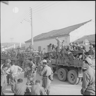 Embarquement d'éléments d'infanterie coloniale et du 379e GT à bord de véhicules GMC.