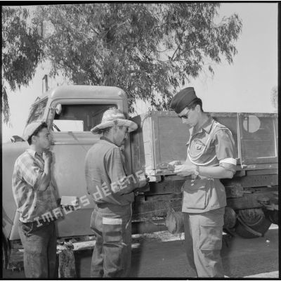 Un soldat de la 279e compagnie de circulation routière (CCR) vérifiant les papiers d'identité de passagers d'une camion.
