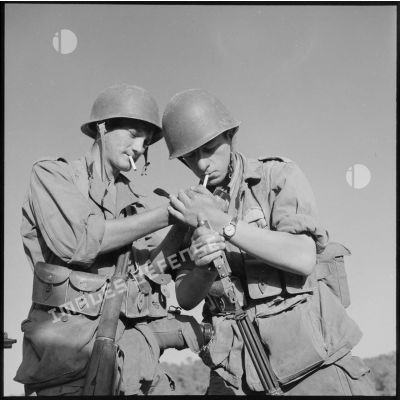 Des soldats fumant une cigarette.