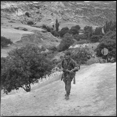 Un soldat de la 4e compagnie du 14e régiment de chasseurs parachutistes (RCP) ramènant des armes récupérées lors de fouilles.