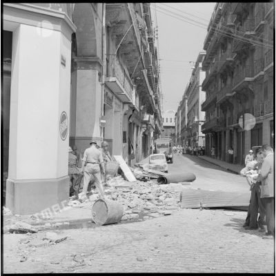 Des soldats et des pompiers d'Alger déblayant les débris d'un immeuble détruit par l'explosion d'une bombe à Alger.