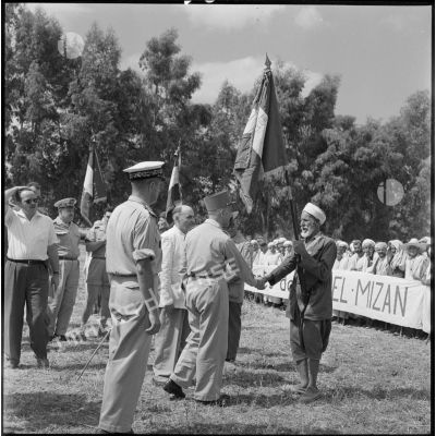 Le général Olié salue les drapeaux des anciens combattants algériens de la CM de Dra-el-Mizan.