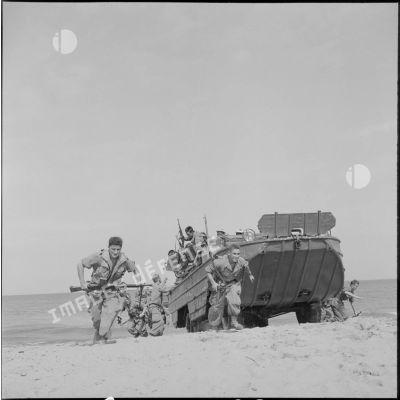 Débarquement des DUKW 353 et déploiement des soldats sur la plage.