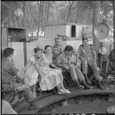 Trois soldats du commando marine de Montfort et deux jeunes étudiantes d'Alger installés sur une petite voiture d'un manège s'amusent.