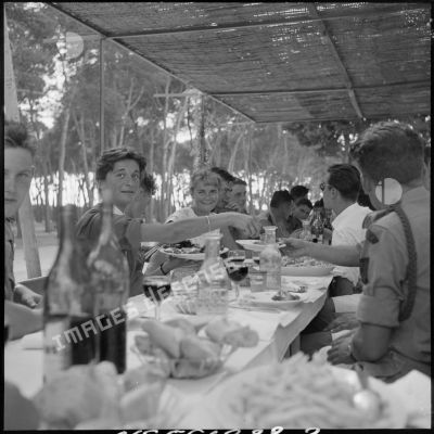 Au cours du repas fraternel au restaurant La gondole. Une jeune étudiante d'Alger sert de la viande à un soldat.