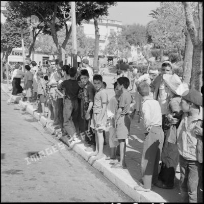 Les enfants algériens regardent arriver le début du défilé.