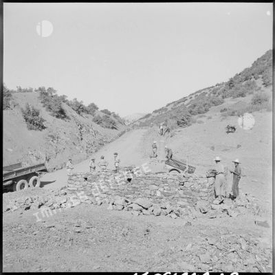 En bord de piste, des soldats du 50e BG surveillent l'avancée des travaux.
