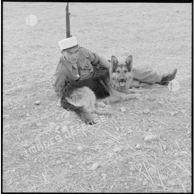 Un maître chien du pelloton cynophile pose avec son berger allemand.