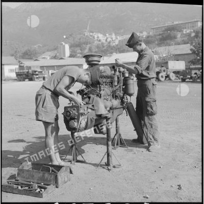 Des soldats de la 69e CRD révisent un moteur.