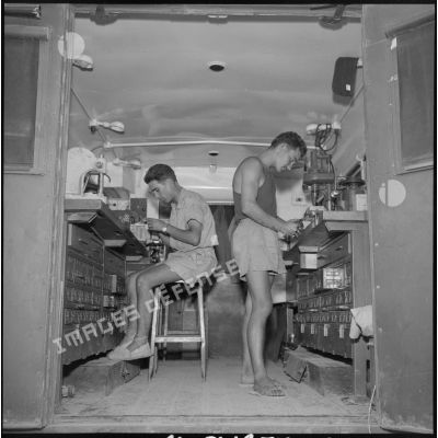 Deux soldats de la 69e CRD travaillent à l'intérieur d'un atelier de mécanique mobile.