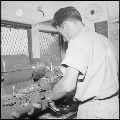 Un soldat de la 69e CRD travaille sur une machine dans un atelier.
