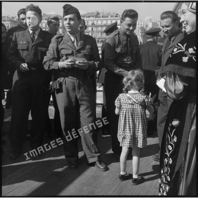 Une jeune fille distribue des cigarettes aux rappelés à bord du Kairouan.