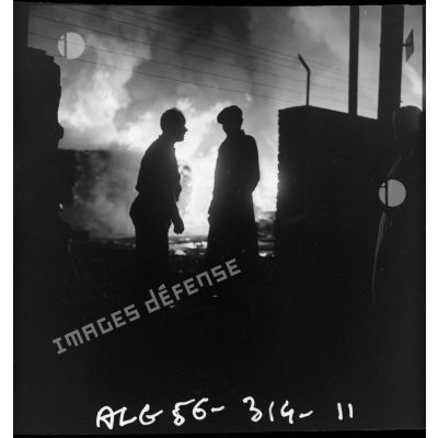 Deux hommes discutent devant l'incendie.