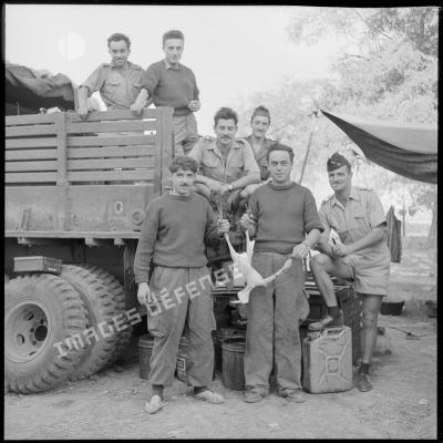 Portraits d'un groupe de rappelés du 10e régiment de dragons (RD) devant un camion militaire.
