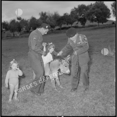 Le sergent Chébila et le caporal-chef Jannicaud jouent avec les enfants de Hamma Plaisance.