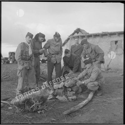 Un groupe d'hommes de la 4e DIM tente de se réchauffer autour d'un feu, dans les environs de Mostaganem.