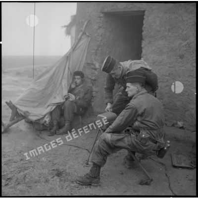 Dans les environs de Mostaganem, les hommes chargés des transmissions de la 4e DIM tentent de s'abriter de la pluie.