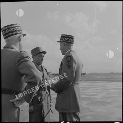 Discussion entre les généraux Lorillot et Salan et un général de corps d'armée sur la base aérienne de Maison-Blanche, le jour de la passation de commandement.