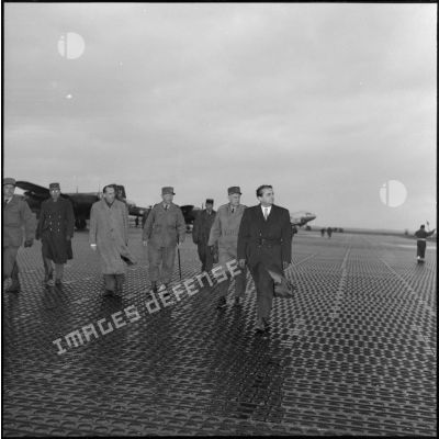Accompagnés d'officiels, le secrétaire d'état aux forces armées Max Lejeune et le général Salan arrivent sur le tarmac de l'aérodrome de la base aérienne de Dôme (BA 213).