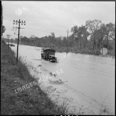 Passage de plusieurs jeep de l'armée sur un chemin inondé près de Bône, le jour de la visite du général Salan et du secrétaire d'état aux forces armées Max Lejeune.