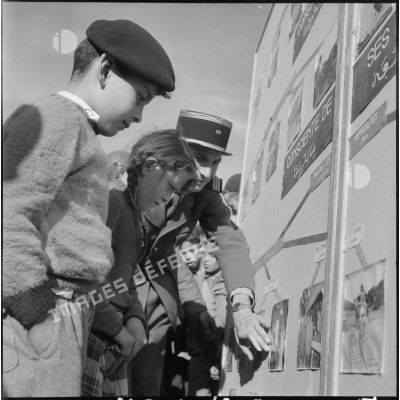 Le capitaine Pasciuto de la CPHT (compagnie de haut-parleurs et de tracts) montrant des panneaux photographiques, dans le cadre de l'action psychologique, à des enfants de Guelma.