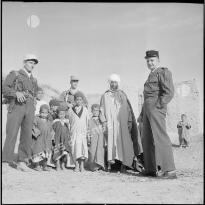 Le lieutenant d'Arbonmont accompagné d'officiers de l'opération de recherche d'Adjoul-Adjoul, du bachaga et d'enfants de Zeribet El Oued.