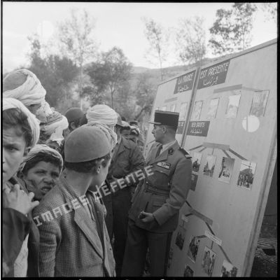 Un capitaine légionnaire présente des panneaux photographiques aux habitants de Gallieni dans le cadre de l'action psychologique.