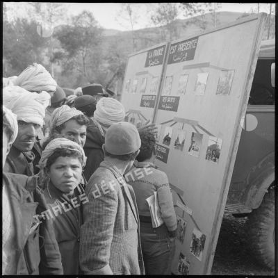 Rassemblement d'habitants de Gallieni devant les panneaux photographiques préparés par la compagnie de haut-parleurs et de tracts.