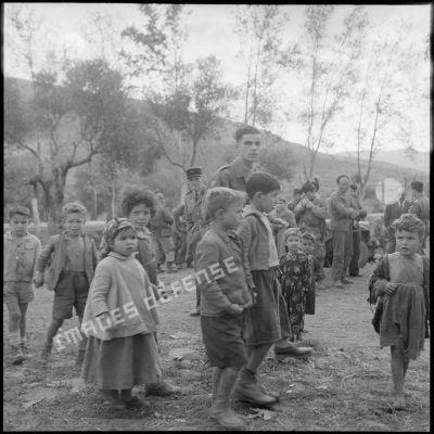 Des enfants du village de Gallieni et un appelé de la 54/2 écoutent le discours de la CHPT.