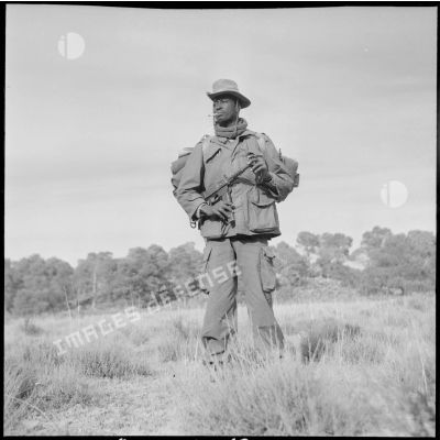 Un tirailleur du 24e régiment d'infanterie coloniale (RIC) fume une cigarette lors d'une mission de reconnaissance dans la forêt des Beni-Melloul (région de Biskra).