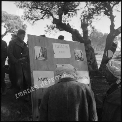 Panneau photographique présenté par une compagnie de haut-parleurs et de tract (CHPT) devant la population masculine algérienne d'un village.