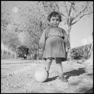 Portrait d'une petite fille algérienne avec son ballon sur une route de Blida.
