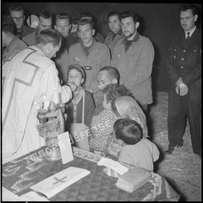 Distribution de l'hostie par l'aumônier militaire à de jeunes kabyles lors de la messe de minuit à Ouadhia.