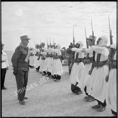 Le général Balmitgère passe en revue la garde d'honneur du 2e peloton de la compagnie méhariste du Tassili (CMT) à l'aérodrome de Fort Polignac.
