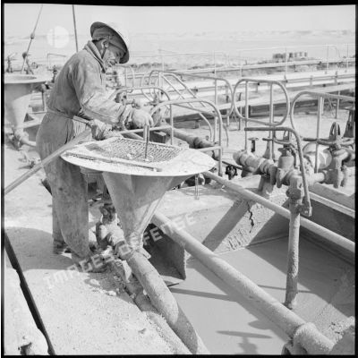 Un ouvrier de la Compagnie française des pétroles en Algérie travaillant sur le site pétrolier d'Hassi Messaoud.