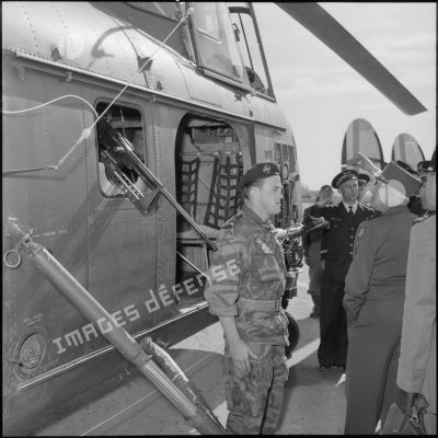 Le général Salan inspecte un hélicoptère Sikorsky équipé d'un canon sans recul de 57 mm et d'une mitrailleuse Reibel en sabord.