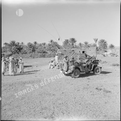 Une jeep passe dans une mechta, secteur d'Aïn Sefra.