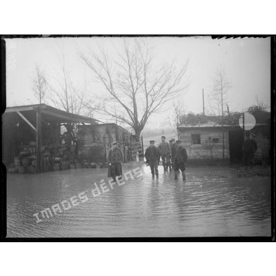 Près de Westvleteren (Belgique). Soldats belges circulant dans le cantonnement inondé, chaussés de bottes en caoutchouc. [légende d'origine]