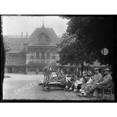 Hôpital militaire canadien de Saint-Cloud, blessés au repos sur la terrasse devant le tableau d'affichage. [légende d'origine]