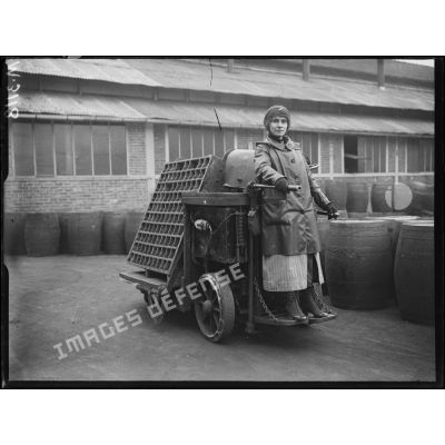 Usines Citroën du quai de Javel. Femme conduisant un chariot électrique servant au transport des obus. [légende d'origine]